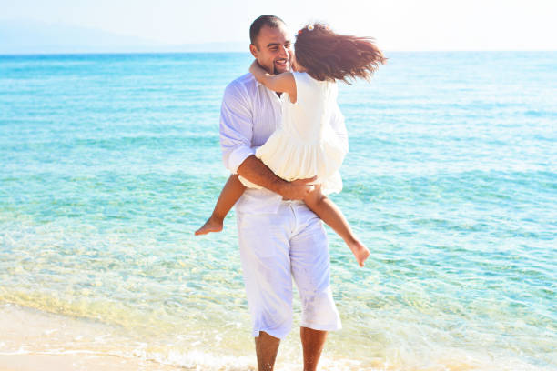 istock Father and daughter play on the beach 938089292