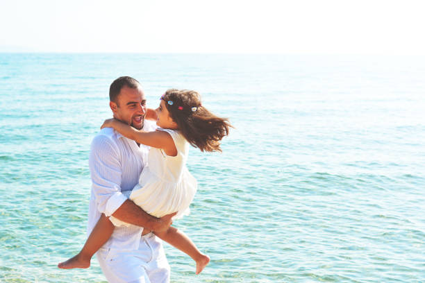 istock Father and daughter play on the beach 938089464