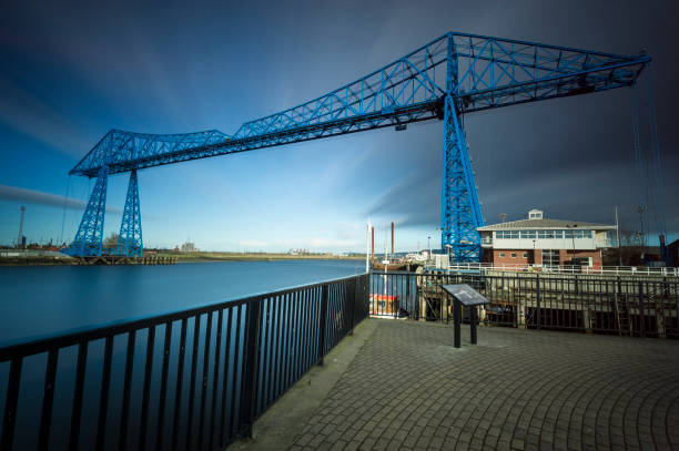 Teesside Transporter Bridge with Blurred Motion in the Sky and Water Teesside Transporter Bridge with Blurred Motion in the Sky and Water, this bridge is over 100 years old and is still in use today, it carries vehicles across the River Tees using a platform suspended by cables. middlesbrough stock pictures, royalty-free photos & images
