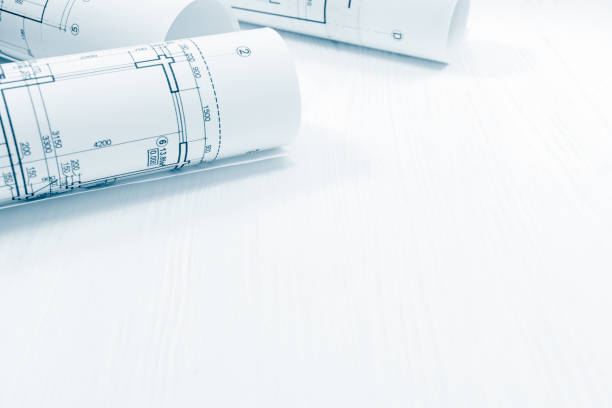 istock roll of architectural blueprints and engineering drawings on white background 938096162