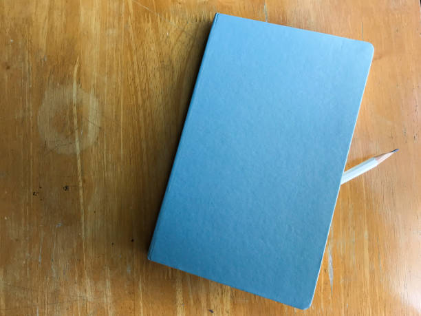 istock White pencil sandwich between Notebook on wood background, Close up 938100084