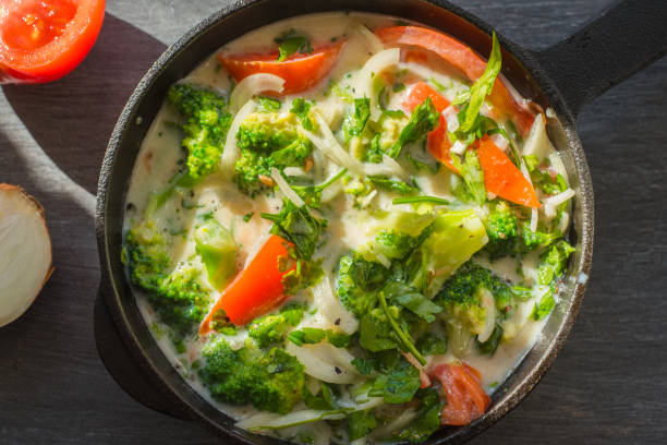 istock Mixed raw eggs, broccoli and tomatoes and vegetables in a frying pan - cooking omelette tomatoes 938100196