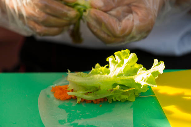 istock Chef cooking steps to make fresh spring rolls with salad vegetable and Shrimp Eggs on hand cook, in outdoor restaurant kitchen. 938100284