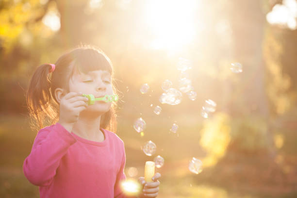 istock Little girl is blowing a soap bubbles 938100334