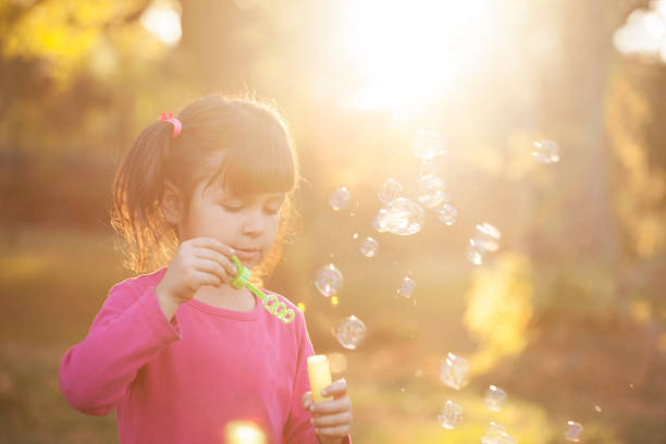 istock Little girl is blowing a soap bubbles 938100458