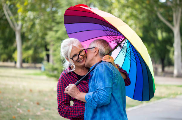 istock The old couple in the rain with umbrellas 938109498