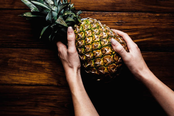Directly above shot of hands holding pineapple stock photo