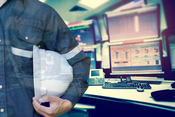 istock Double exposure of Engineer or Technician man holding safety hat with computer monitor control room for stock and control process industrial business concept. 938119648