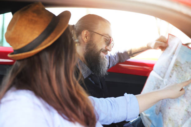 istock Happy young couple with a map in the car 938122908
