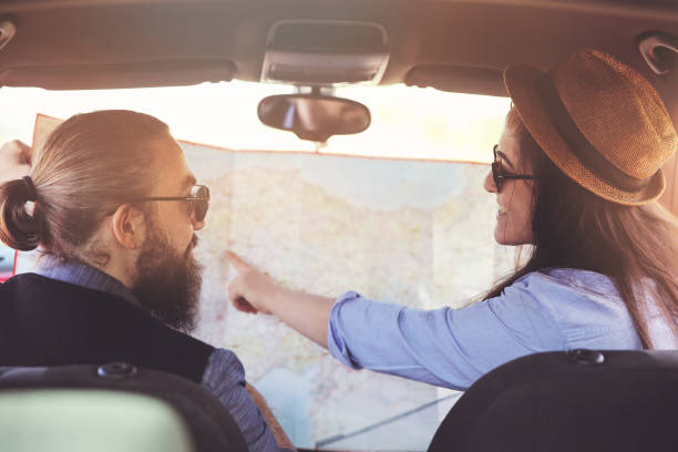 istock Happy young couple with a map in the car 938122930