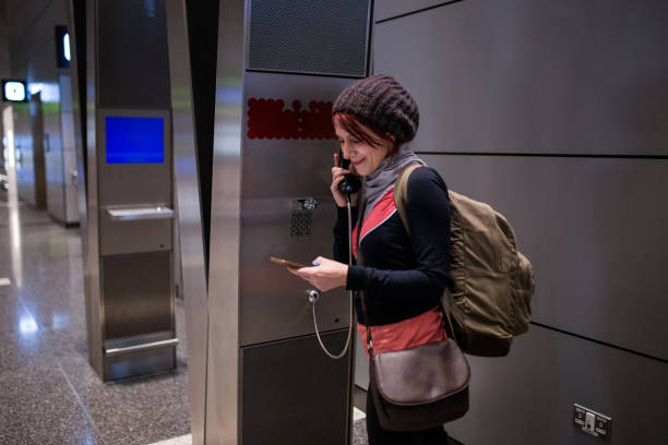 istock Woman Using Phone Booth At Airport 938124014
