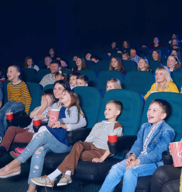 istock sideview of happy children watching movie. 938127708