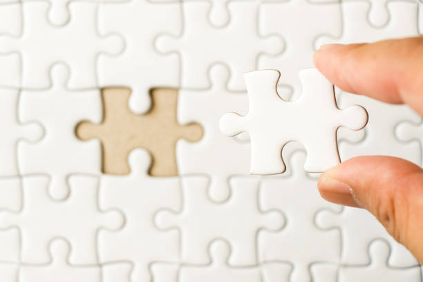 istock Closed up background of white plain jigsaw with hand that hold missing piece to match or fulfill 938131028