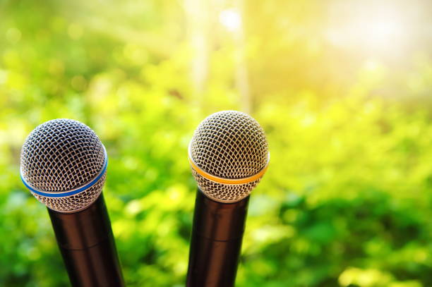 istock two metal black microphone for speech or communication in green environmental background 938131250