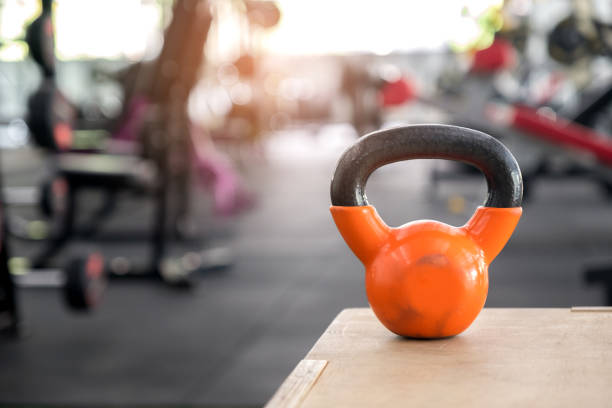 istock Orange kettlebell put on a wooden crate. 938131354