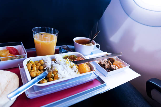 photo of Food served on board of economy class airplane on the table photo of Food served on board of economy class airplane on the table. set of Asian food. meals on the folding table in front of the aircraft window airplane food stock pictures, royalty-free photos & images