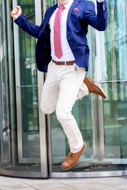istock headless businessman jumping in front of office building 938137976