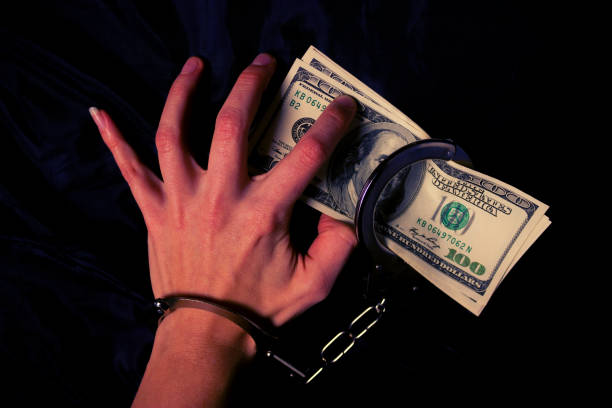 istock women's hands in handcuffs with dollars 938141626