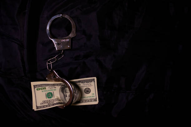 istock women's hands in handcuffs with dollars 938141646
