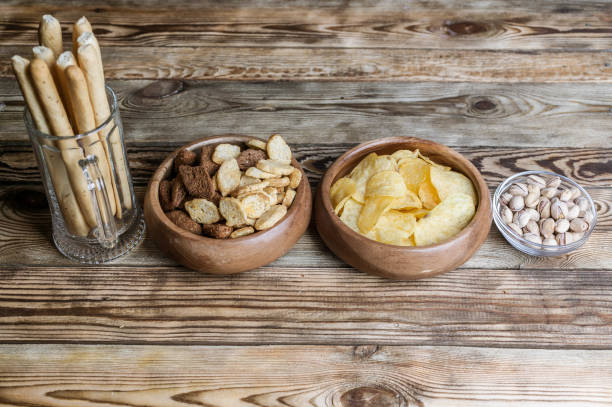 istock Snacks for beer on a wooden table. Chips, croutons, bread sticks and pistachios 938146134