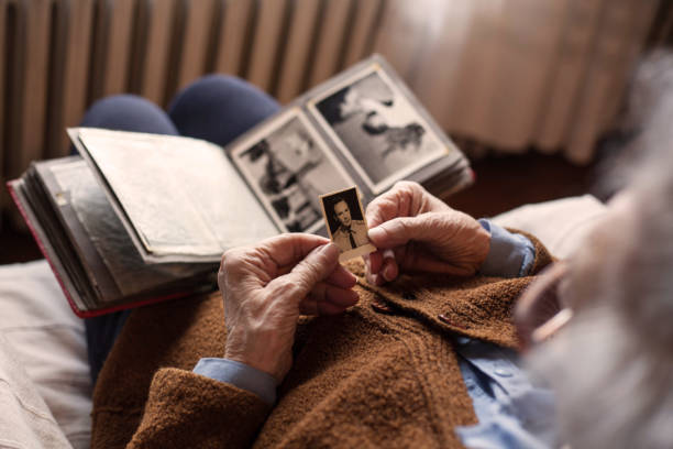 Memories. Senior adult woman looking at an old photo of her husband. family trees stock pictures, royalty-free photos & images
