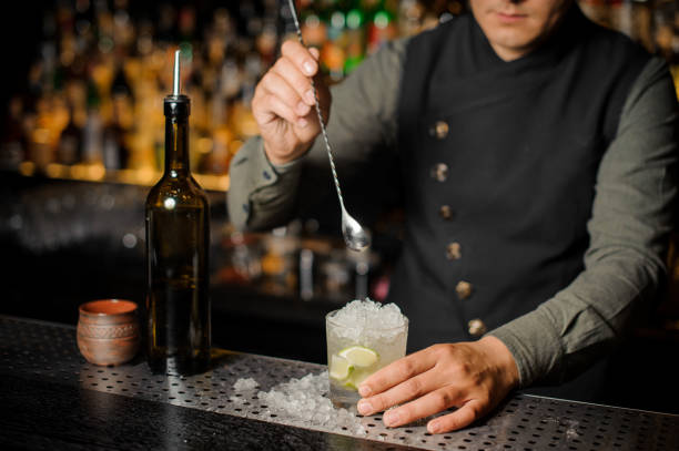 istock Barman stiring a fresh delicious cocktail with lime and cane sugar 938154736