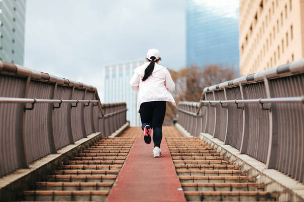 mujer con sobrepeso en escaleras - staircase running moving up jogging fotografías e imágenes de stock
