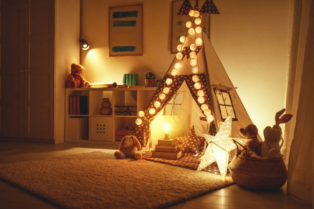 wnętrze pokoju zabaw dla dzieci z namiotem, lampami i zabawkami w ciemności - domestic tent zdjęcia i obrazy z banku zdjęć