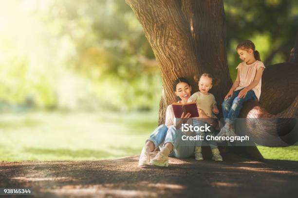 Mom Reading A Book To Her Children Stock Photo - Download Image Now - Reading, Family, Child