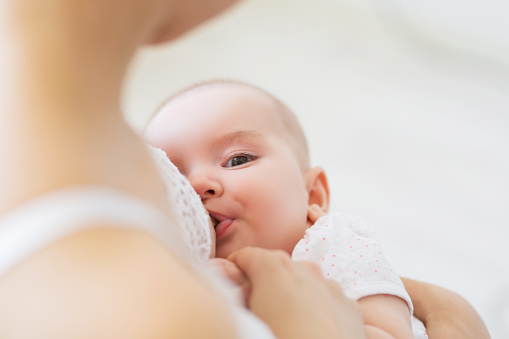 Mama de joven madre alimentando a su niño recién nacido. Concepto infantil de la lactancia. La madre alimenta a su hijo o hija con la leche materna photo
