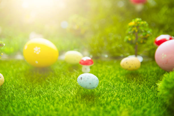 istock Happy Easter concept. Easter eggs on green grass. Fairy tale sunset on the plastic green field with plastic grass, mushrooms and trees. Fake grass. Macro 938166990