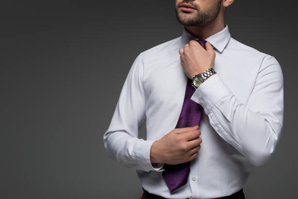istock Cropped image of businessman correcting tie isolated on grey isolated on grey 938167370
