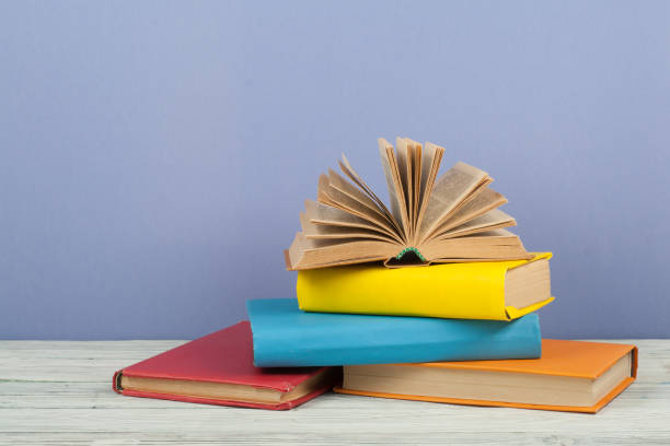 istock Open book, hardback colorful books on wooden table. Back to school. Copy space for text. Education business concept 938171040