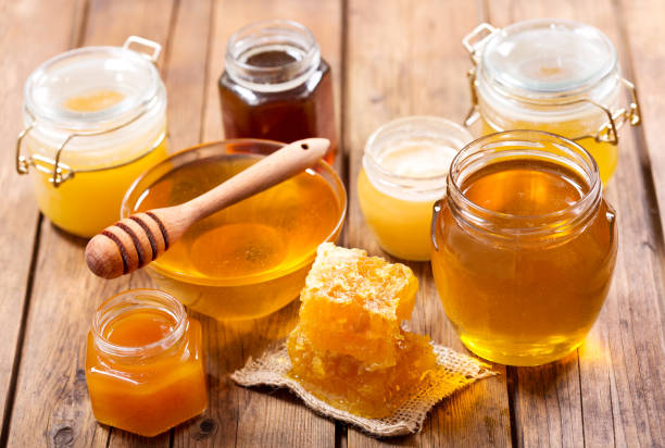 various types of honey in glass jars stock photo
