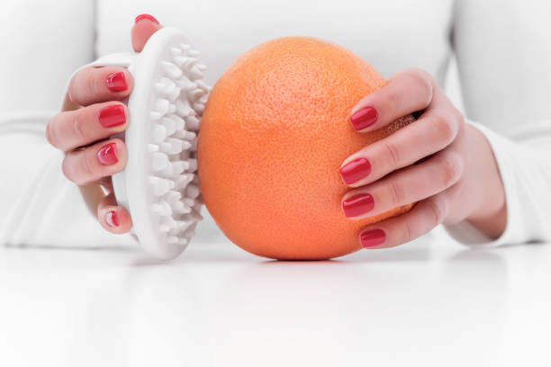 masajeador anticelulítico y naranja. - celulitis tipos de piel fotografías e imágenes de stock