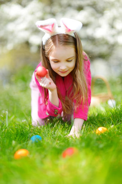 istock Adorable little girl hunting for Easter egg in blooming spring garden on Easter day 938178662