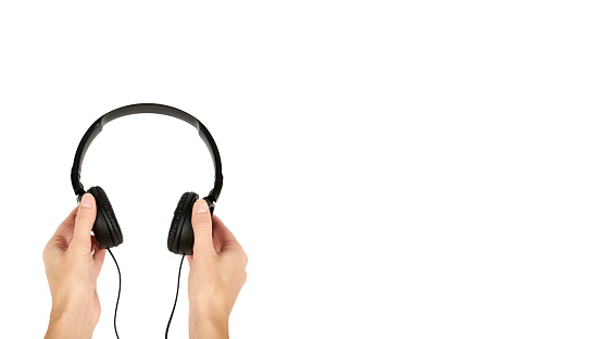 Black headphones in hand isolated on white background. copy space, template.