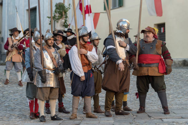 Medieval costume party Taggia, Italy - March 17, 2018: Participants of medieval costume party in the historic city of Taggia in Liguria region of Italy. The actors acting out episodes of daily life in settings that evoke moments of life lived fully the seventeenth century. The episodes depicted are inspired by true events, drawn from documents preserved in the Historical Archives rifle old fashioned antique ancient stock pictures, royalty-free photos & images