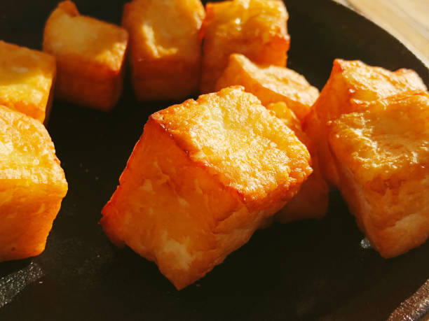 Deliciously fried cheese cubes on a dark plate