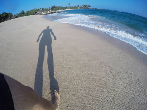 istock Long shadow of a man on the beach by blue ocean in summer 938193530