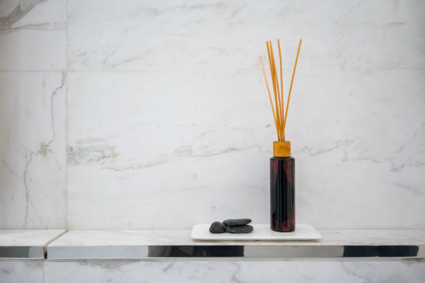 istock Scented diffuser stick in black glass bottle against white marble wall background for decoration in luxury bathroom. 938194502