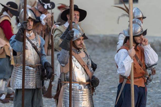 Medieval costume party Taggia, Italy - March 17, 2018: Participants of medieval costume party in the historic city of Taggia in Liguria region of Italy. The actors acting out episodes of daily life in settings that evoke moments of life lived fully the seventeenth century. The episodes depicted are inspired by true events, drawn from documents preserved in the Historical Archives rifle old fashioned antique ancient stock pictures, royalty-free photos & images