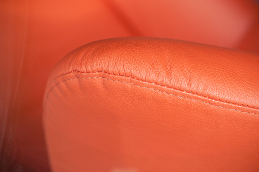 closeup of orange leather sofa armrest