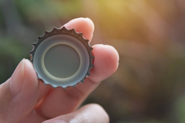 hand holding a bottle caps on nature background. - cork tops imagens e fotografias de stock