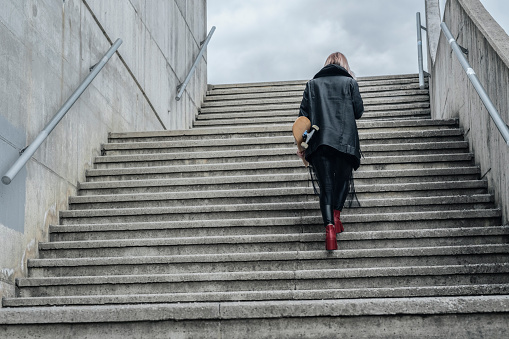 Young fashionable woman with skateboard.