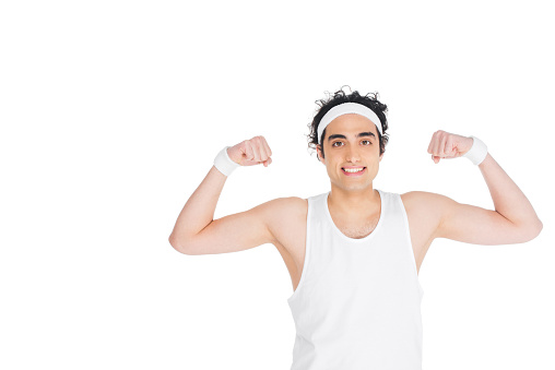Young thin man in singlet showing muscles isolated on white