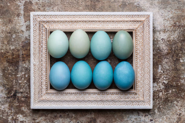 istock Happy Easter rustic background with copy space. DIY dyed various shades of blue Easter eggs and vintage wooden picture frame mock up. 938209220