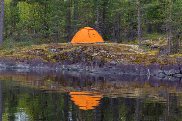 istock Tent on the shore and its reflection in the water. 938210826