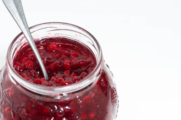 istock jar with sweet cowberry jam on white table, closeup 938211498