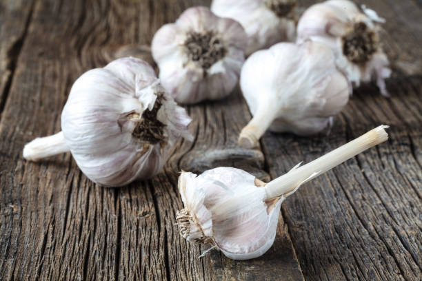 istock Dry ripe garlic head on wooden table 938214804
